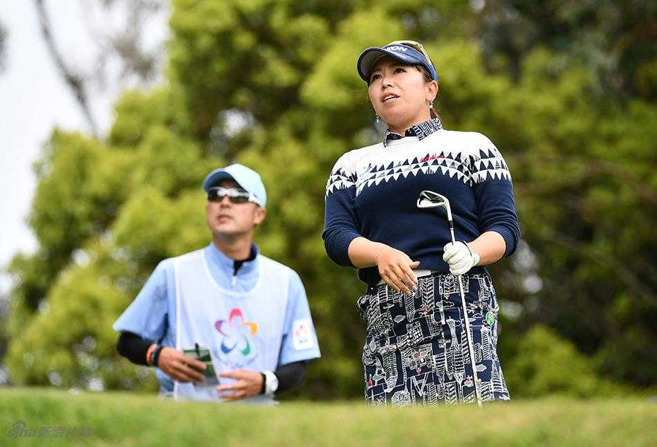 堀琴音在果岭边仔细观察球线，表情专注，为关键推杆做最后准备。