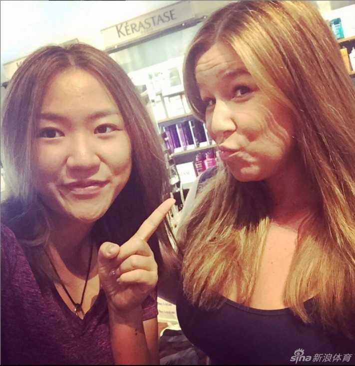 宝拉-克里默与丈夫在机场牵手漫步，两人对视微笑，行李箱上绑着此次英国女子公开赛的行程标签