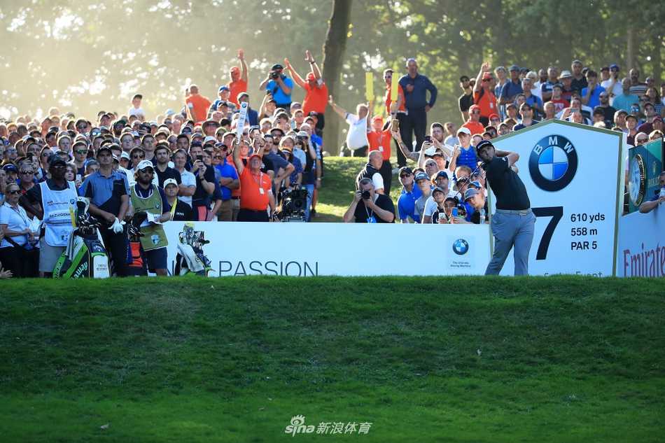 比赛现场，其他球员如汤米·弗利特伍德正在果岭上仔细研判推杆线路，神情严肃。