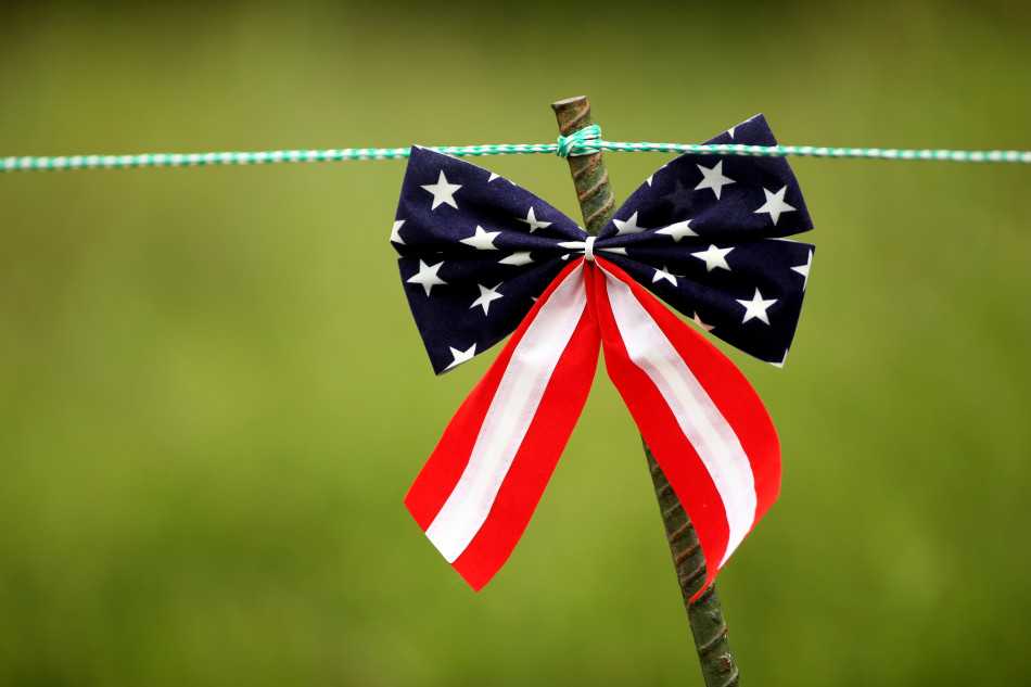 特写镜头下，旗杆顶端以美国国旗布料精心制作的蝴蝶结，在阳光下色彩鲜艳，彰显出仪式细节的极致考究。