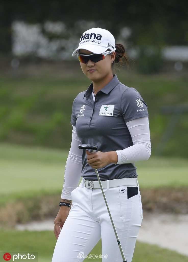 李旻智与球童在球道上认真讨论下一杆的策略，展现团队协作。