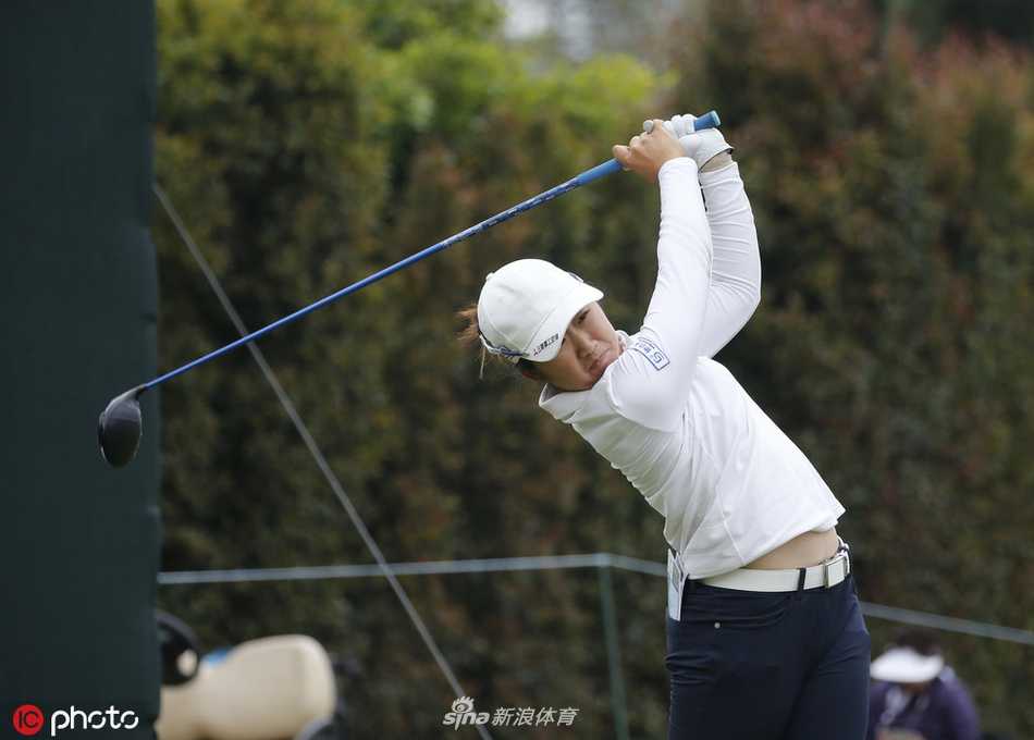 赛事现场，观众聚集在果岭周围，屏息凝神观看选手推杆。