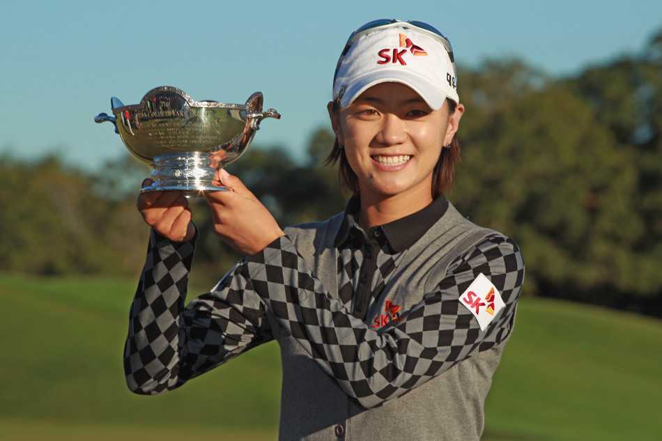 崔罗莲与冠军奖杯合影，灿烂的笑容如同阳光，这是努力终于开花结果的最幸福时刻。