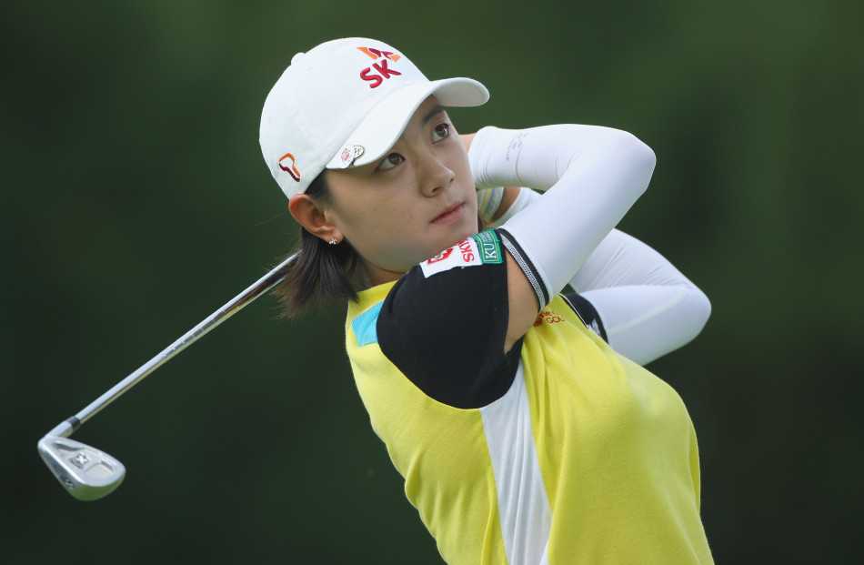 崔罗莲蹲在果岭旁仔细阅读草纹，手中的推杆与她的目光一样沉稳，为关键一推做足准备。