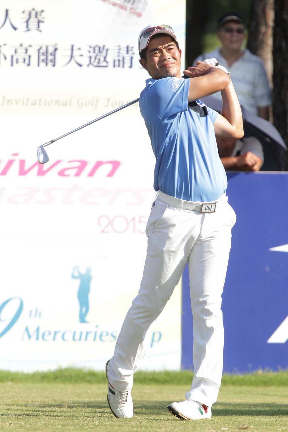 梁文冲全神贯注凝视推杆路线，阳光洒在果岭上勾勒出他沉稳的身影