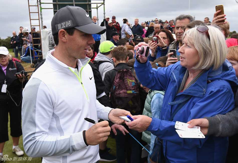 亲和的巨星：麦克罗伊面带微笑，耐心地为围栏外兴奋的球迷签名留念。