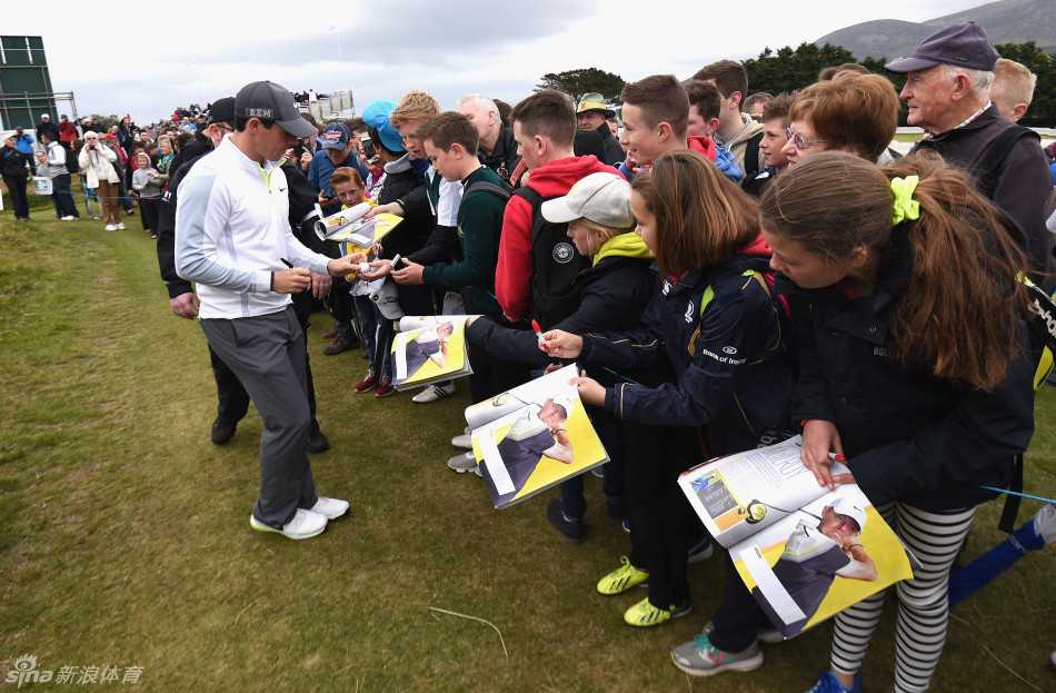 热情的中心：麦克罗伊被众多球迷簇拥，他正满足一位女球迷的签名请求，场面热烈而有序。