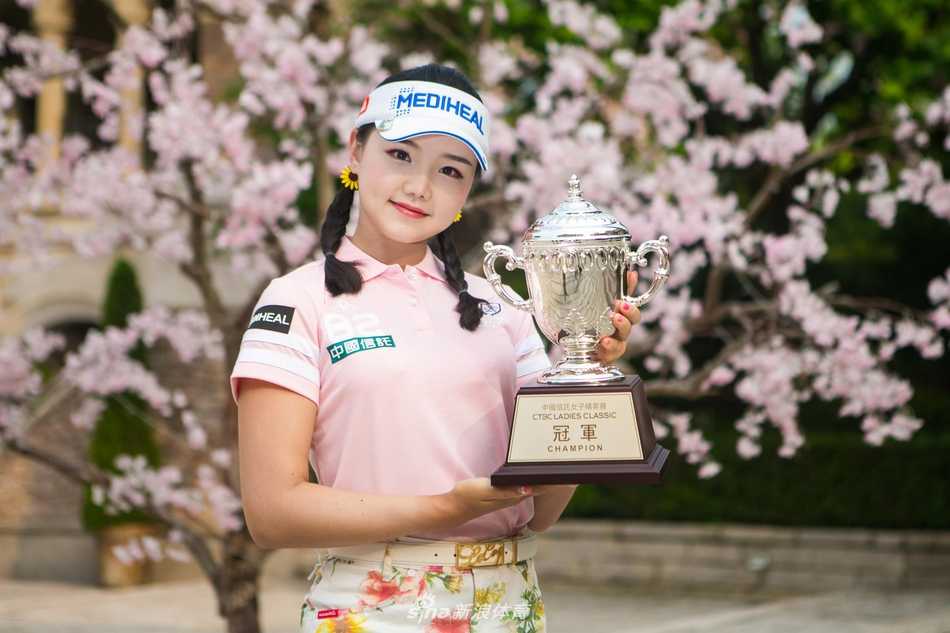 罗莹高举奖杯笑容绽放，银色奖杯与她喜悦的脸庞交相辉映，背景中的人群欢呼仿佛能穿透照片