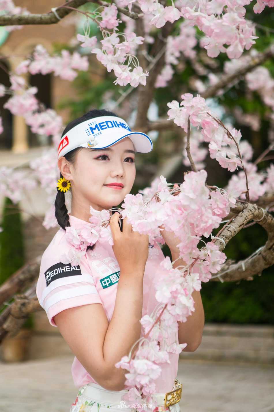 叶欣宁与石昱婷相视而笑，樱花枝头在她们头顶形成天然画框，这份赛场上的情谊比春光更暖