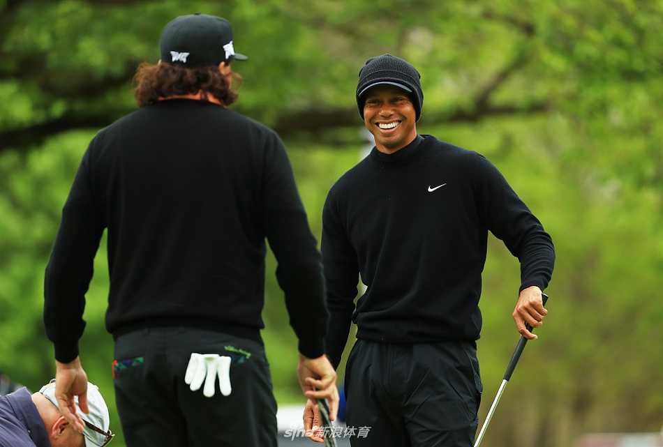 泰格·伍兹凝神推杆，晨光为其身影勾勒出金色轮廓