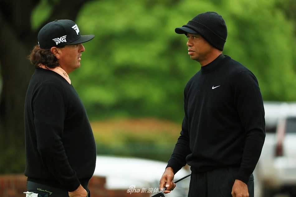 伍兹与同行球员轻松交谈，严肃备战中流露出片刻的松弛与笑容