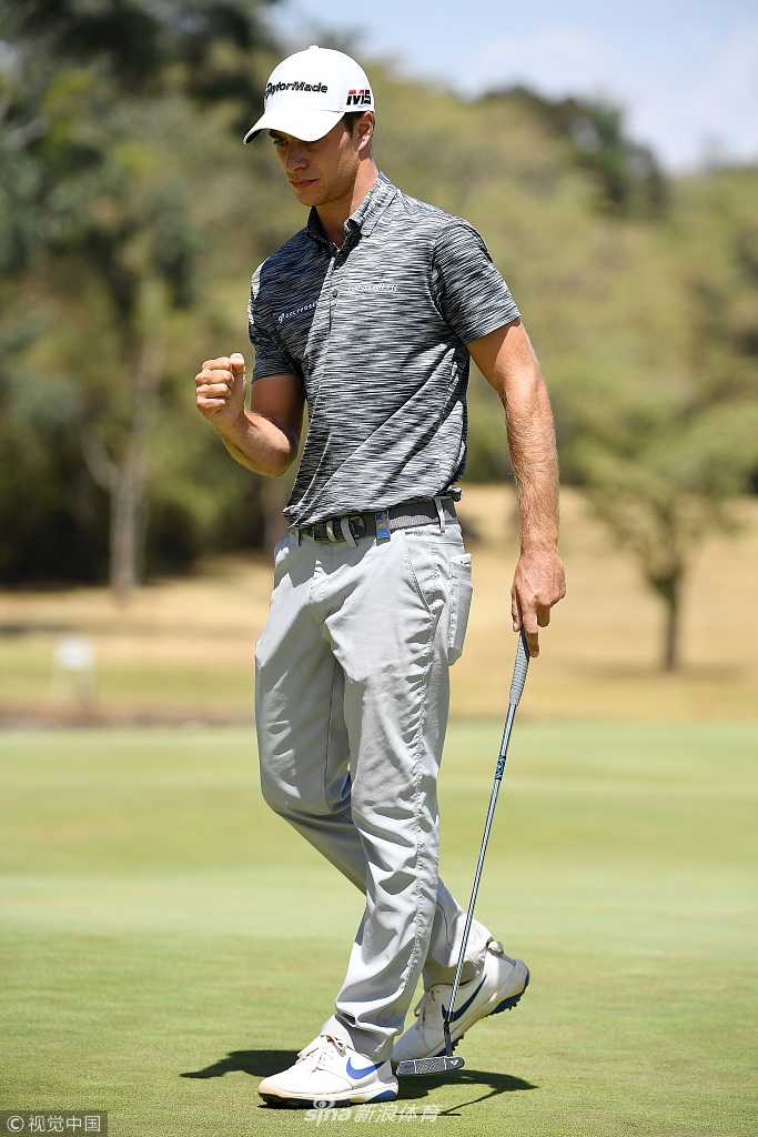 米格里奥兹在颁奖仪式上高举奖杯，笑容灿烂，身后是肯尼亚当地传统服饰的表演者翩翩起舞