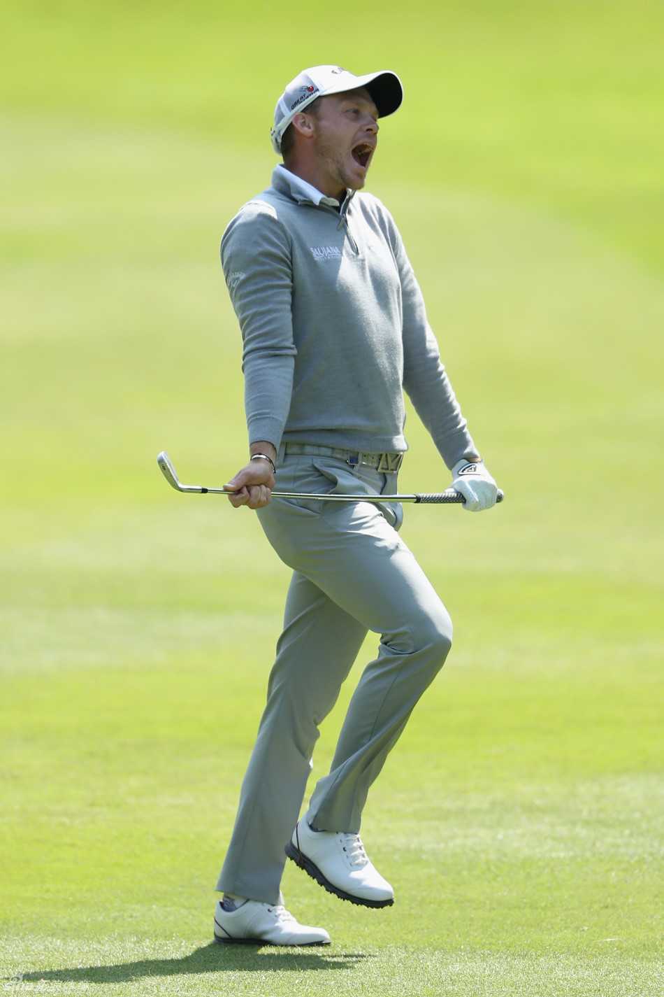 一位球员在果岭上随着小球滚动的路线翩翩起舞，身体语言夸张而喜悦，庆祝一记精彩的推杆进洞