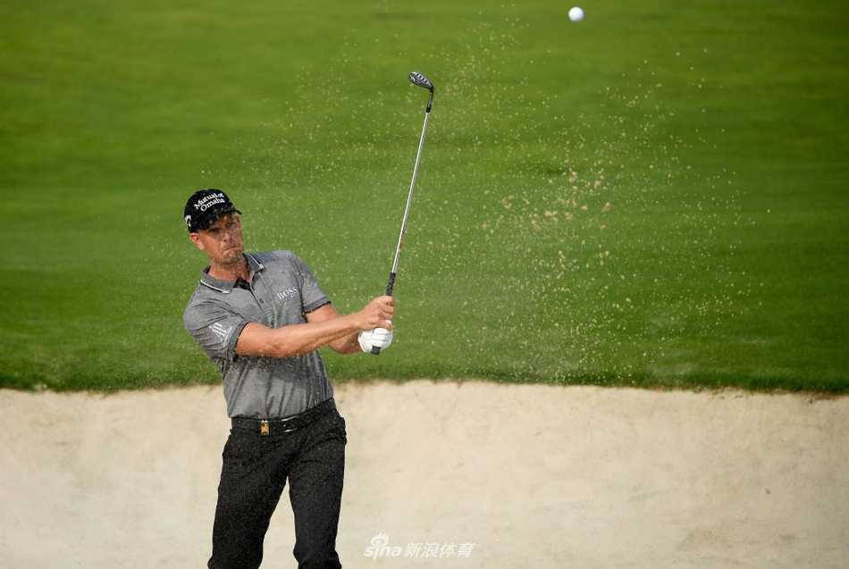 瑞典名将斯滕森在沙坑中处理困难球位，他表情专注，沙坑杆激起一片细沙