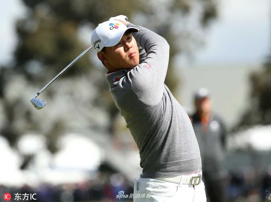 观众聚集在球场边凝神观看比赛，人群背景虚化突出现场专注而紧张的观赛氛围