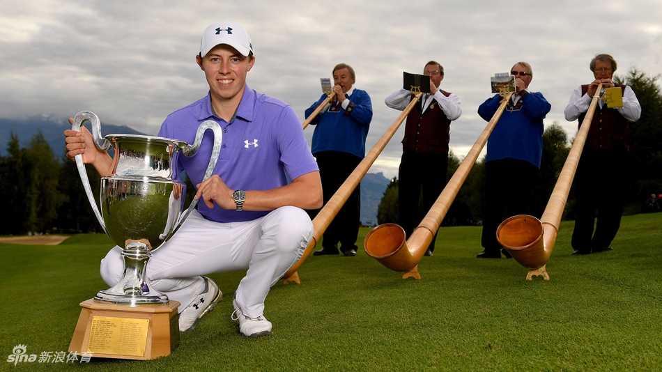 马修·菲茨帕特里克在瑞士阿尔卑斯山的背景下，身披冠军红色夹克，高举欧洲大师赛奖杯庆祝胜利。