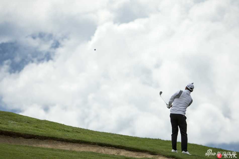 吴阿顺与球童在果岭边密切交流，认真研究推杆线路，展现团队协作的力量。