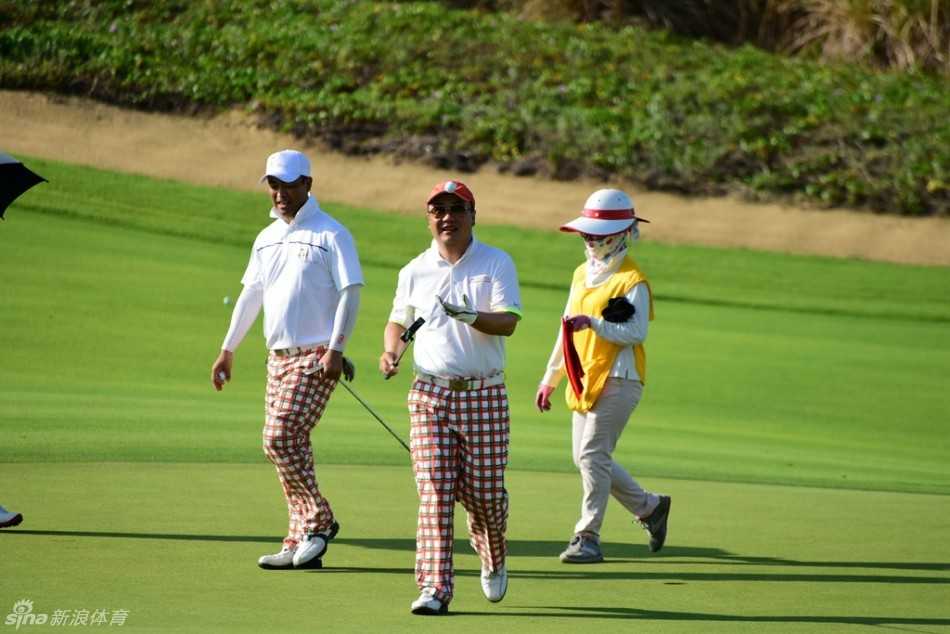 队员俯身仔细观察球线，指尖轻触草叶感受坡度与湿度