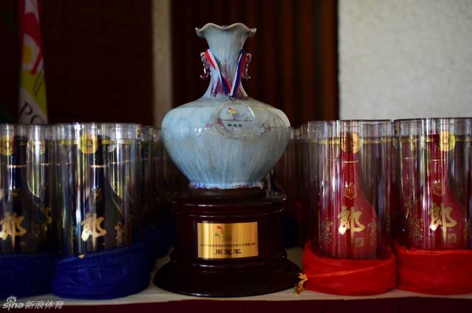 金色奖杯特写，表面倒映着蓝天白云与选手喜悦的脸庞