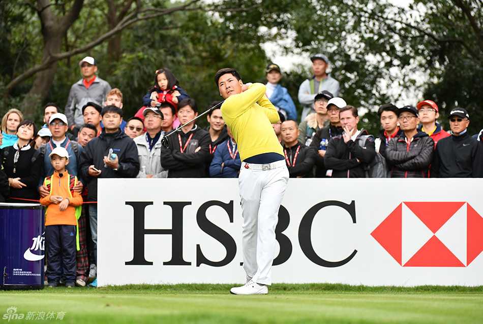 张新军在全神贯注地准备开球，背景中可清晰看到同组的世界级球星麦克罗伊，中国红与冠军气质同框。