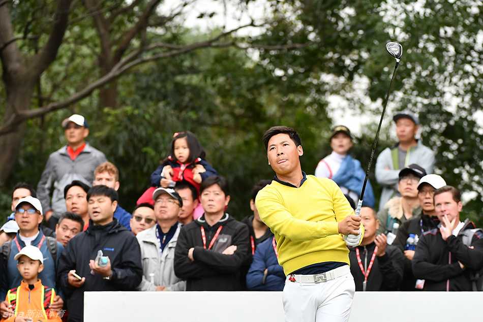 张新军与麦克罗伊并肩行走在球道上，进行着友好的技术交流，体现了高尔夫运动尊重与学习的宝贵精神。