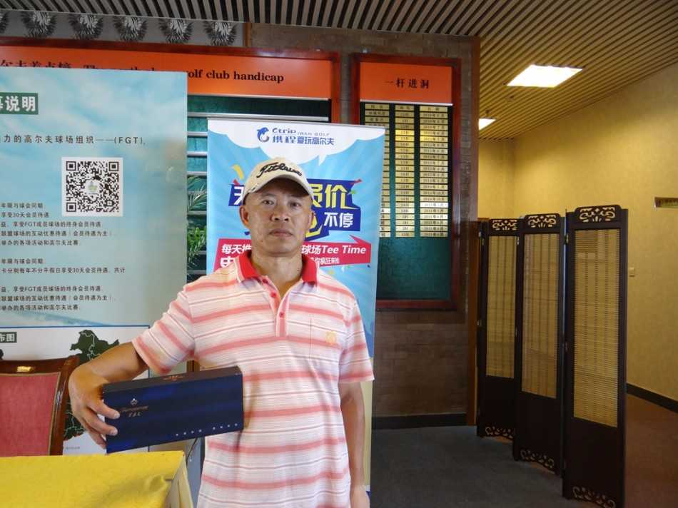 阳光明媚的高尔夫球场上，一位球手正专注地推杆，远处是宁静的湖泊与起伏的果岭，构成一幅和谐的运动画卷。