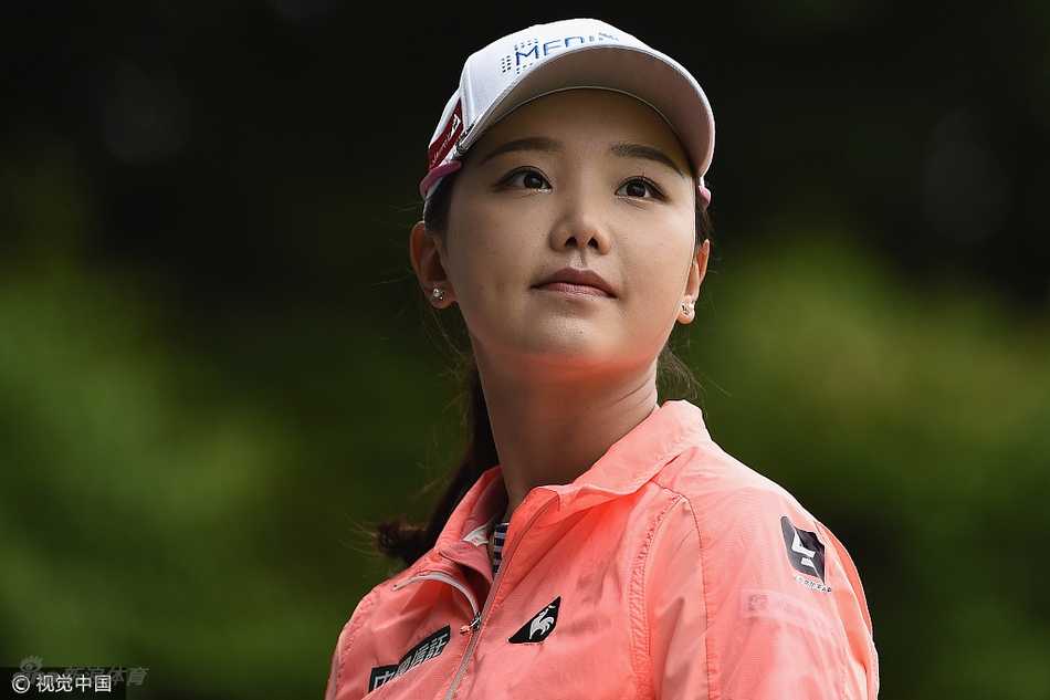 石昱婷神态放松，面带微笑走在绿意盎然的球道上，展现出大赛中难得的从容心态