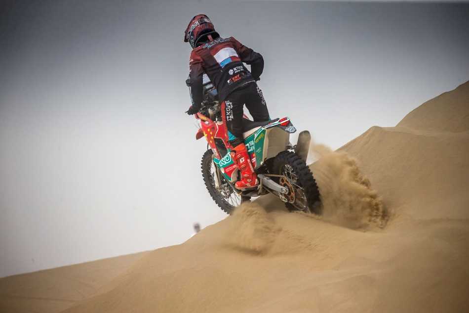 广角镜头下，赛车孤独却坚定地行驶于巨大的沙谷之中，凸显了人类造物在自然奇观面前的渺小与无畏。