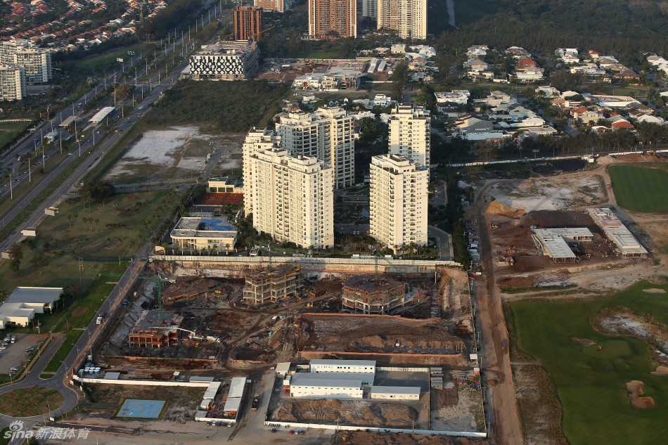 夕阳的金色光芒洒在已初具雏形的球道绿茵上，灌溉系统喷出的水雾折射出彩虹，孕育着一片充满生机的奥运赛场