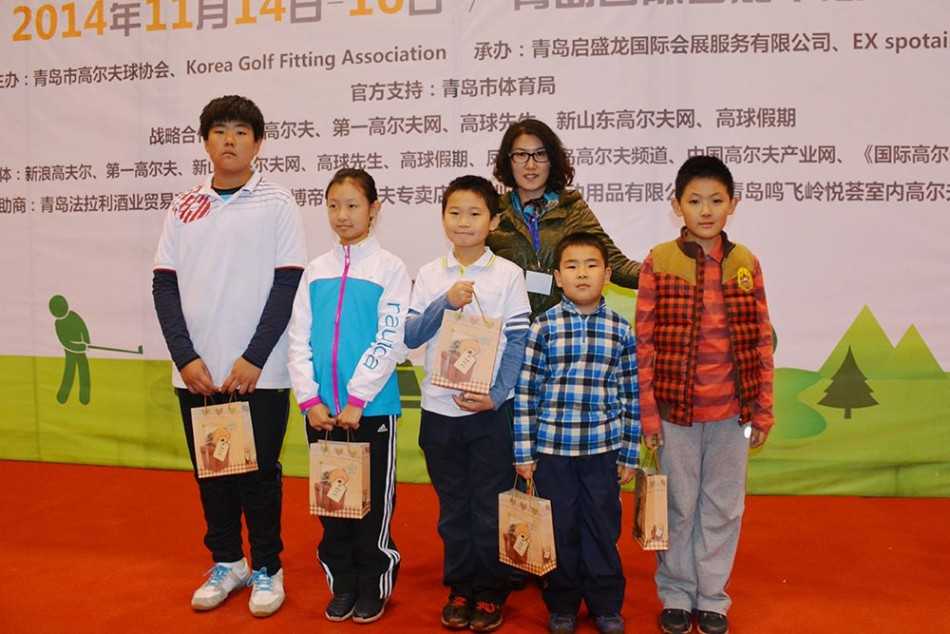 两位小球员正并肩核对成绩卡，神情认真而专注，体现了高尔夫运动诚信自律的精神。