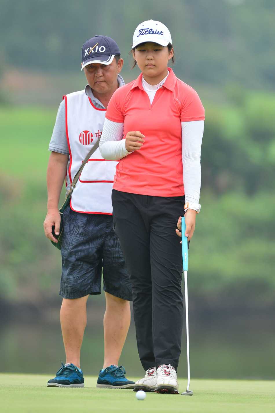 领先组的三位女球员在球道上并肩而行，有说有笑，展现了赛场上的友谊与风采