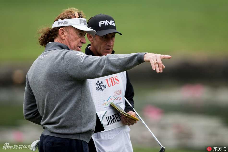 李昊桐在比赛中进行关键推杆，他弯腰仔细审视果岭，全场寂静，气氛紧张而充满悬念。