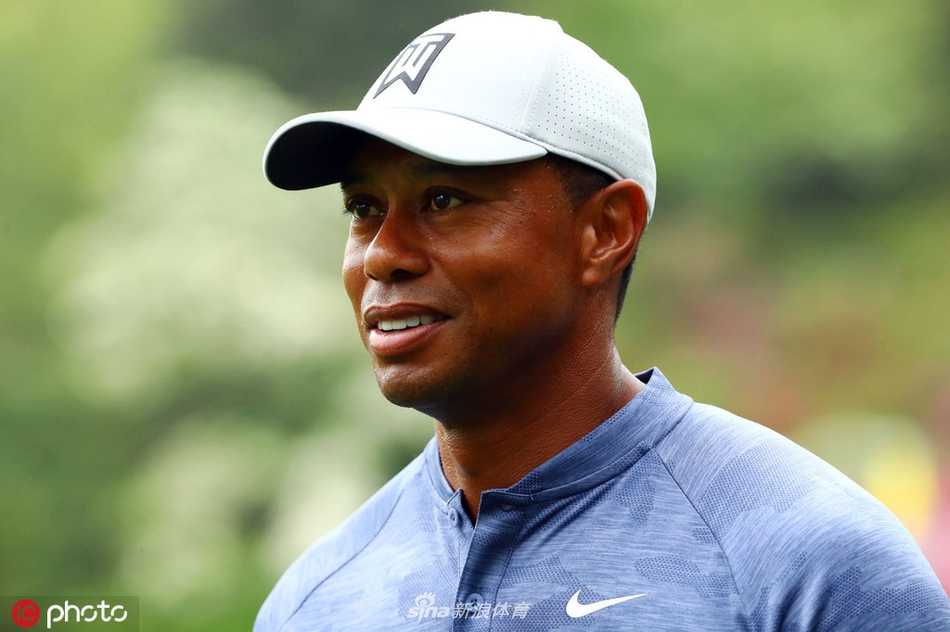 老虎伍兹在奥古斯塔练习果岭上俯身仔细观察推杆线路，神情专注如雕刻