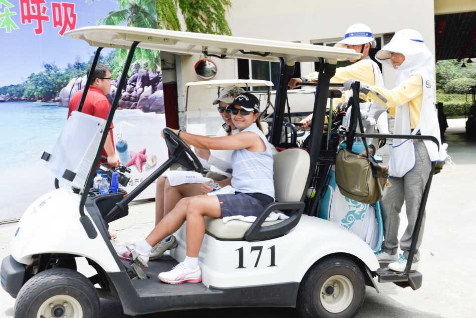 端午节高尔夫活动开球仪式上，嘉宾们手持彩球准备一同开出，背后是碧绿的球场和节日横幅。