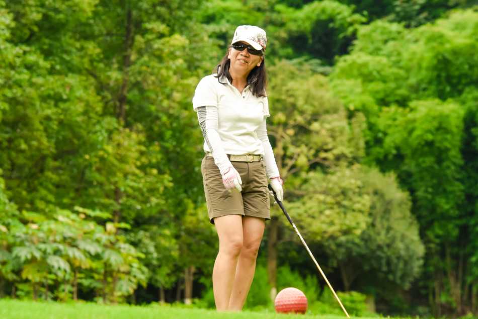 球员在果岭边仔细观察推杆路线，神情专注，正在为关键一击做精心计算。