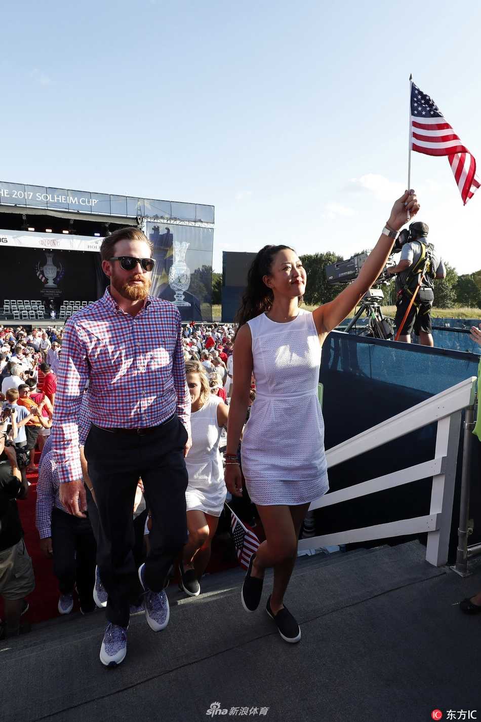 美国队实力战将莱克西·汤普森与队友在开幕式上并肩而立，向观众挥手致意，展现出队伍的团结与自信。