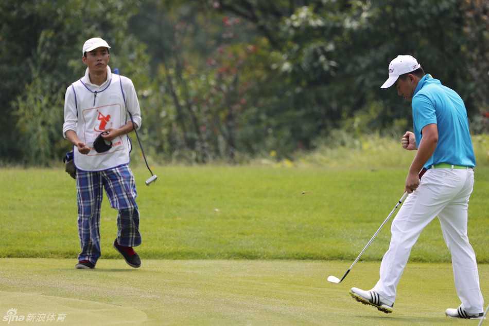 中国高尔夫球员张新军正聚精会神地跪在果岭边缘，双眼如尺般衡量着小白球与球洞之间草皮的细微起伏与转折线路。