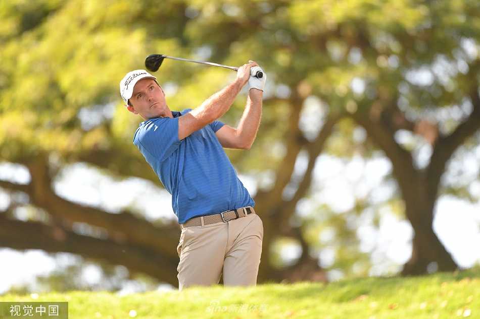 罗素·亨利在第十七洞发球台全力一击，白衣身影在夏威夷的蓝天下划出有力弧线