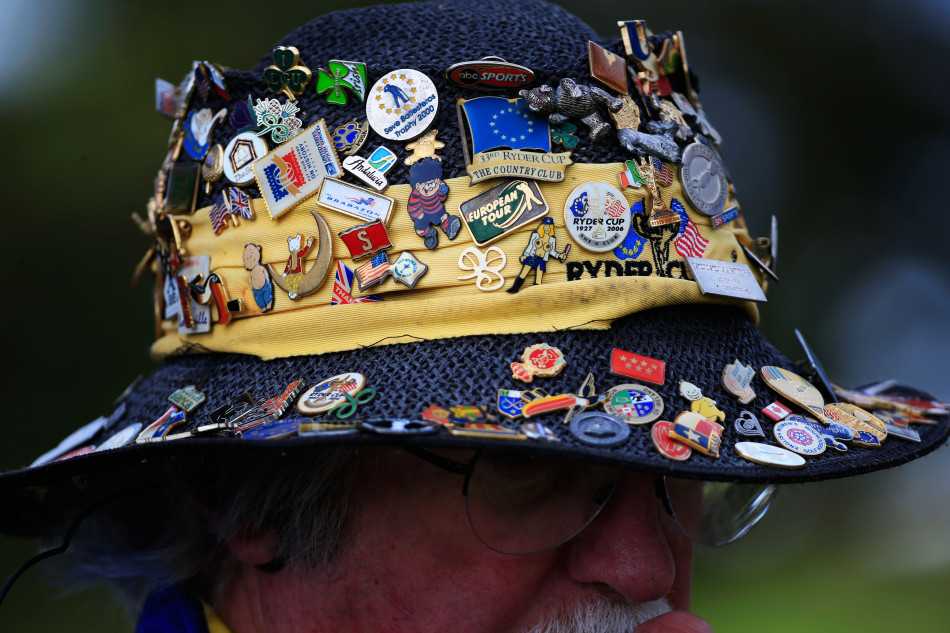 美国队传奇球星菲尔·米克尔森面带微笑，正在高尔夫手套上为一位小球迷签名，身旁围绕着期待的人群。