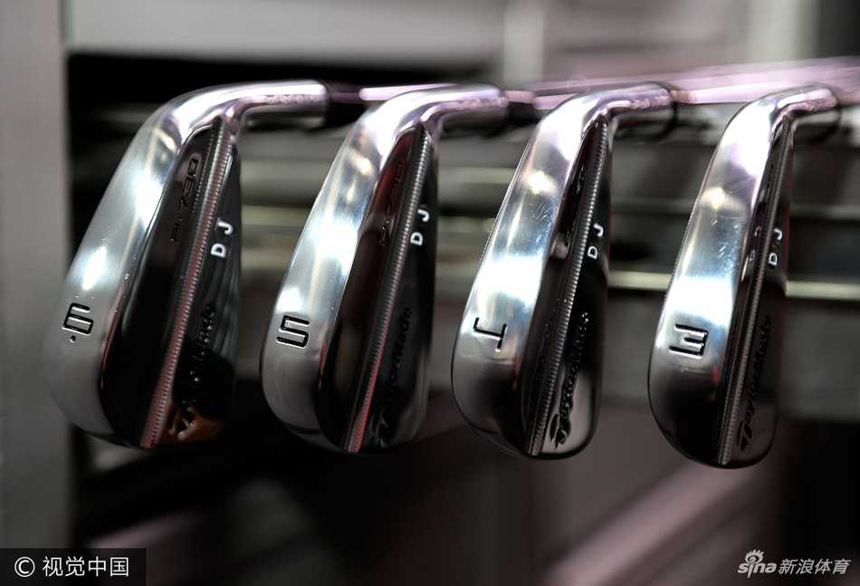 菲尔·米克尔森面带笑容，俯身耐心地为一位小球迷签名，展现其亲民一面