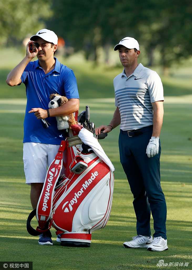 罗里·麦克罗伊与临时球童哈里·戴蒙德在比赛中并肩前行，边走边交流，气氛轻松