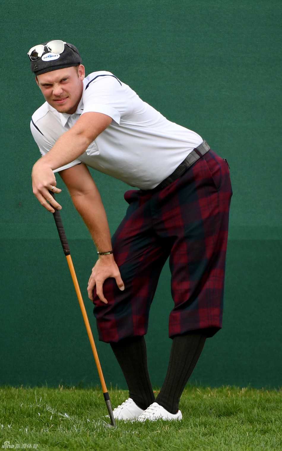 李·维斯特伍德在沙坑中成功击球后，沙砾飞扬，他稳稳保持住收杆姿势，展现出精湛的沙坑球技术和从容的比赛气质。