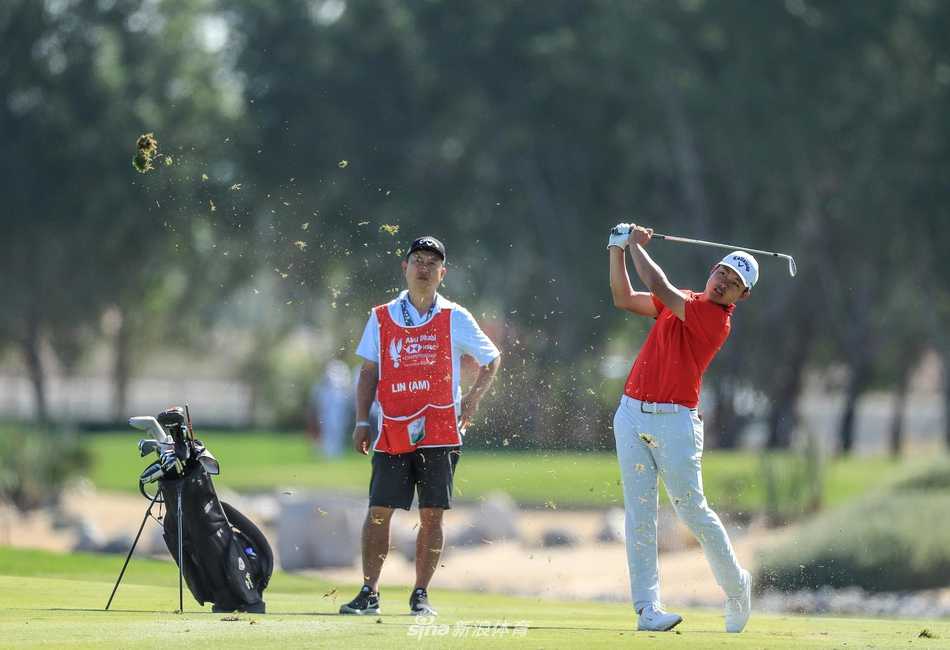 维斯特伍德在第十八洞果岭举起冠军奖杯，笑容灿烂，身后阿布扎比的城市天际线与落日余晖交相辉映