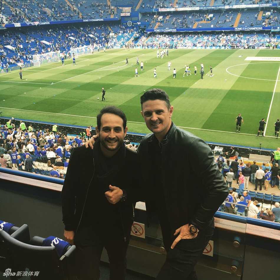 球员在签名区俯身认真为每一位球迷签名，神情专注而友善