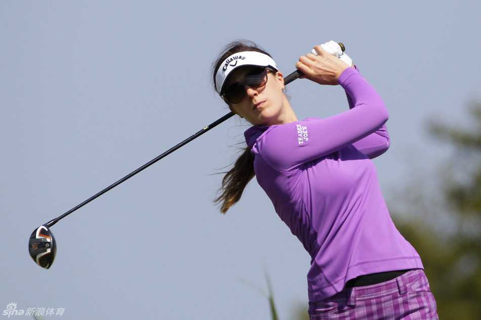 日本选手野村敏京在风中稳固站姿，全力完成一记开球，目光紧锁远方的球道。