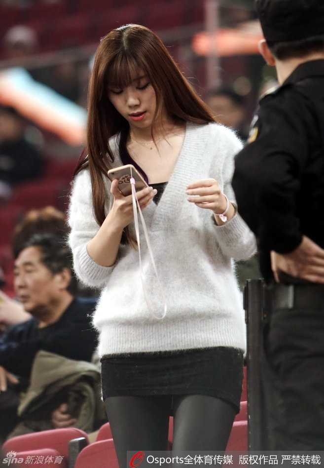 这位美女球迷微微侧首，若有所思，她身后的赛场喧嚣似乎与她无关，她正沉浸在自己对战术的理解之中。