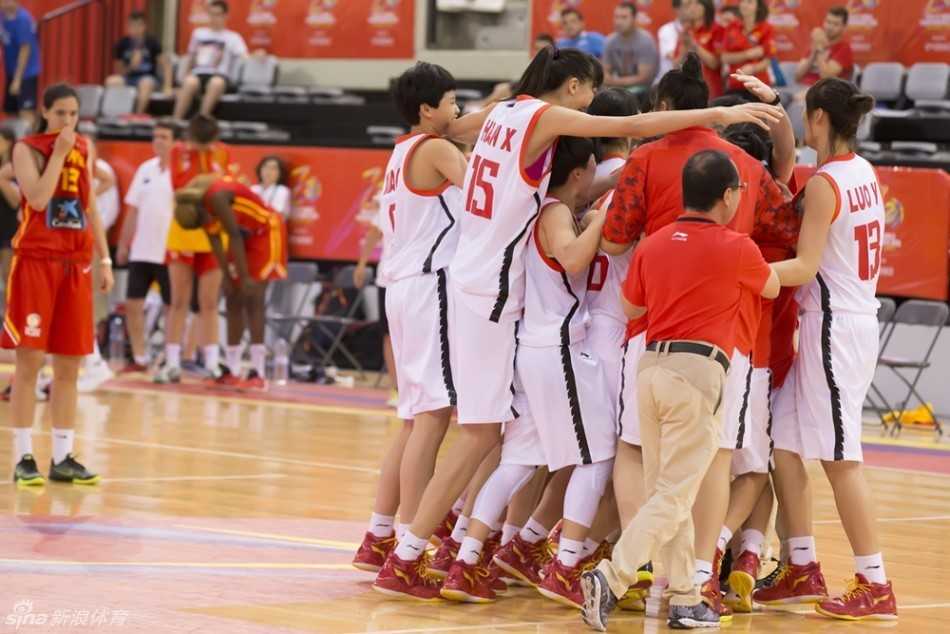 中国队球员在对手严密防守下强行突破上篮，身体在空中完全舒展，展现出极佳的核心力量与进攻欲望。