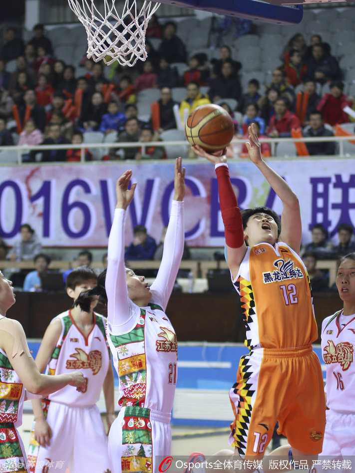 防守球员如影随形紧贴对手，两人的身形在灯光下拉长，仿佛一场无声的角力正在球场上演