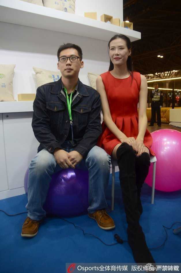 许诺在义卖摊位前，双手比出爱心手势，她身后的墙上贴着为陈鹭芸加油鼓劲的标语，红色的裙摆宛如冬日里的一团火，点燃了现场的爱心与希望。