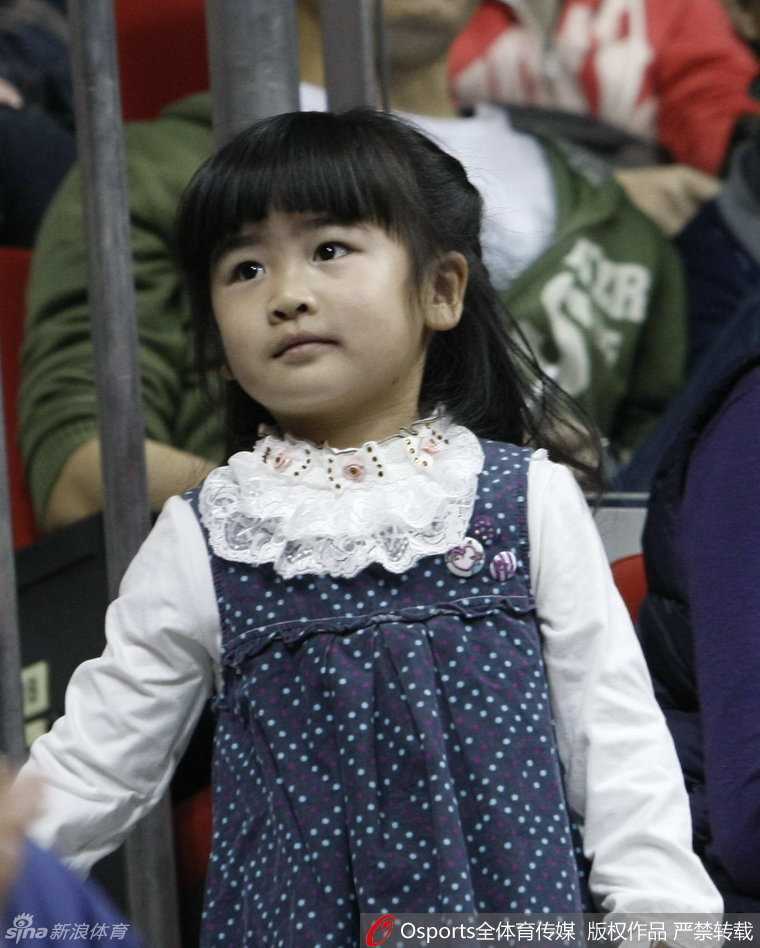 郭士强的女儿被父亲温柔地抱在怀中，小公主般享受着父亲的宠爱，脸上露出天真无邪的笑容，这一幕与郭士强在赛场上严厉的形象形成了有趣的反差。